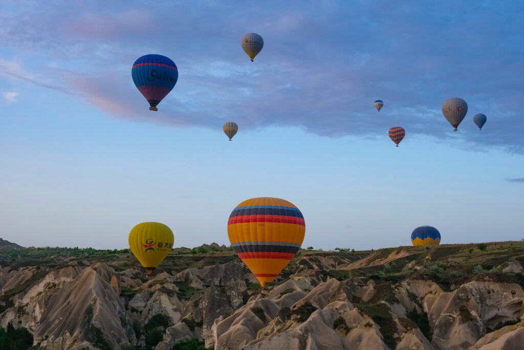 "Multiple hot air balloon flying near the ground." 